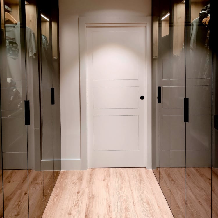 armario vestidor a medida de puertas batientes acristaladas madera oscura luz led integrada