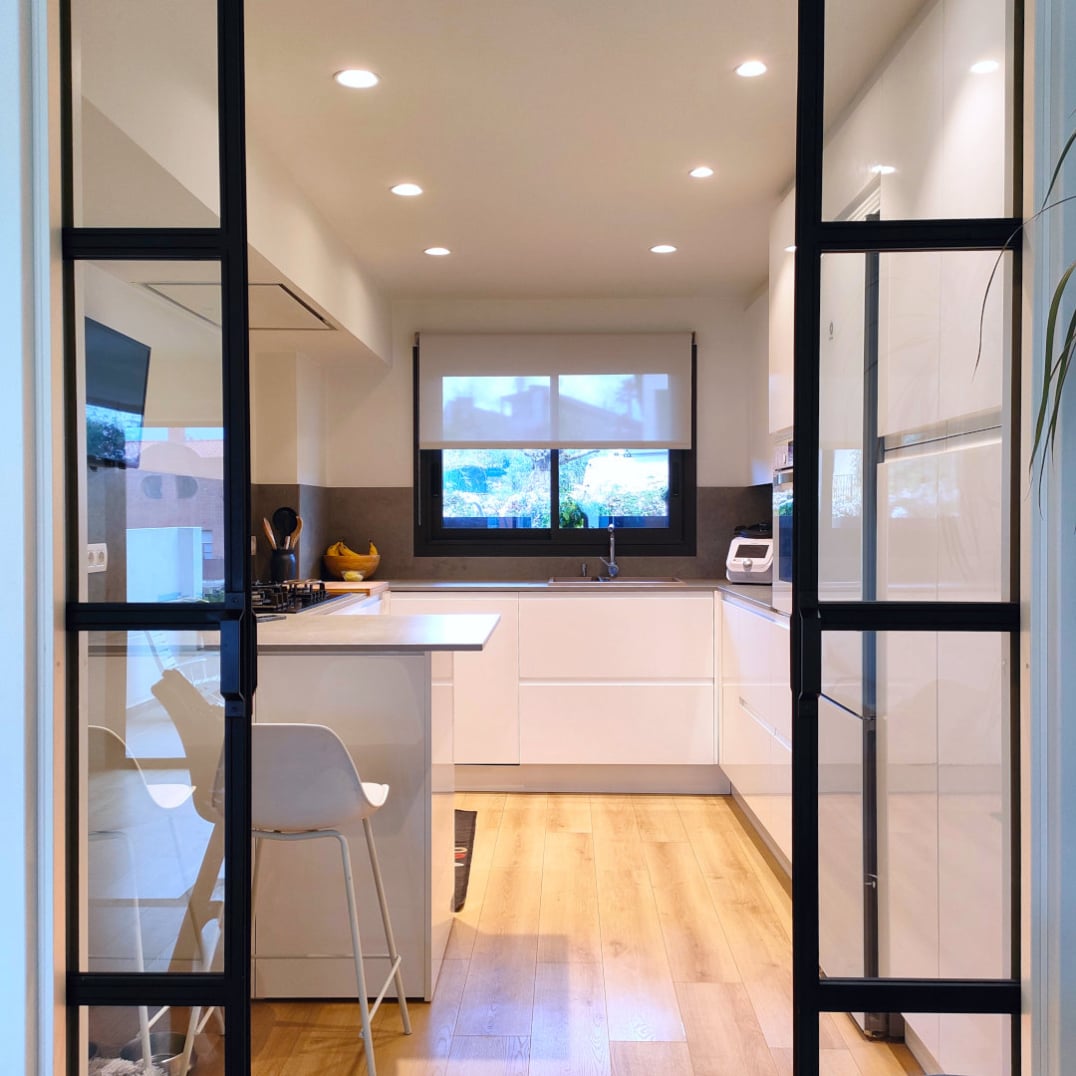 miaje cocina a medida con peninsula blanca abierta puertas acristaladas