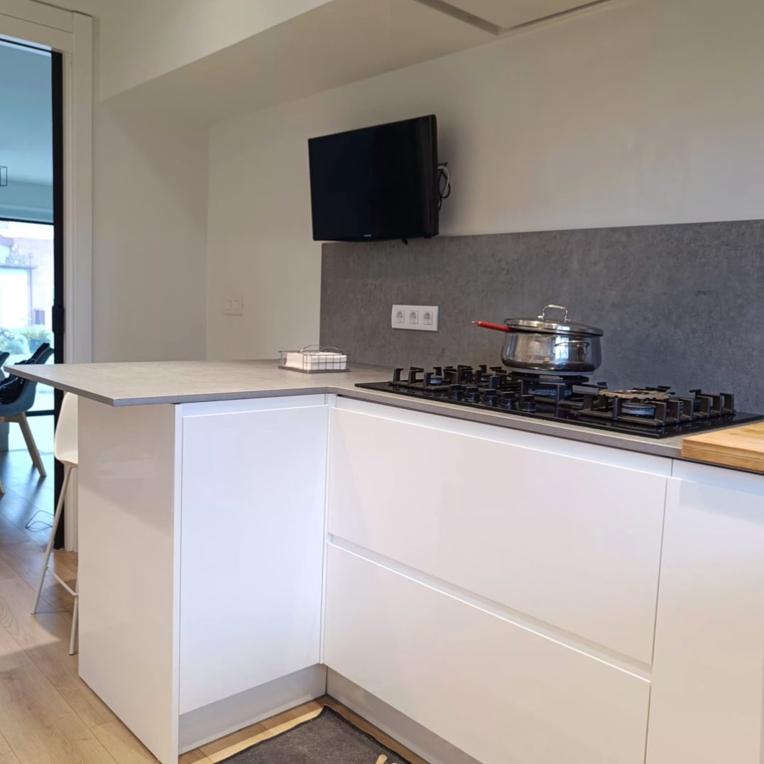 miaje cocina a medida con peninsula blanca abierta puertas acristaladas