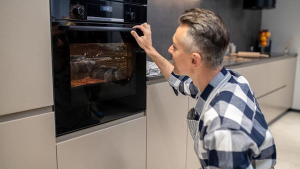miaje hombre en cocina moderna regulando horno